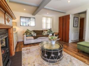 ein Wohnzimmer mit einer Couch und einem Couchtisch in der Unterkunft Gardener's Cottage in Lytham St Annes