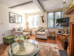 ein Wohnzimmer mit Sofa und Tisch in der Unterkunft Gardener's Cottage in Lytham St Annes