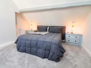 ein Schlafzimmer mit einem großen Bett und zwei Nachttischen in der Unterkunft Gardener's Cottage in Lytham St Annes
