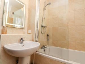 ein Badezimmer mit Waschbecken und Dusche mit Spiegel in der Unterkunft Gardener's Cottage in Lytham St Annes + 16 Fotos