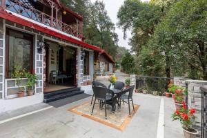 un patio avec des chaises et une table devant un bâtiment dans l'établissement Alaya Stays The Hive Cottage, à Nainital