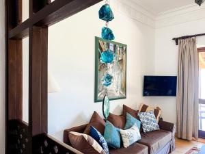 a living room with a brown couch and blue pillows at Vipingo Ridge, The Maridi Villa by Diplo El Homes in Pingilikani