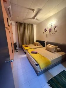two beds sitting in a room with at JJ Homestay Taman Manggis in Balik Pulau
