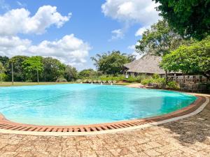 a swimming pool at a resort with blue water at Vipingo Ridge, The Maridi Villa by Diplo El Homes in Pingilikani