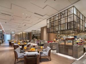a restaurant with tables and chairs and a buffet at Pullman Huai'an in Huai'an