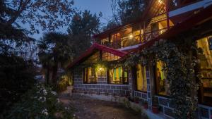 une maison éclairée la nuit avec des lumières dans l'établissement Alaya Stays The Hive Cottage, à Nainital