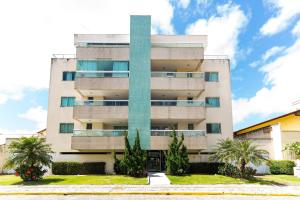 a tall building with palm trees in front of it at Res. Wilian 308 - Apto 2 quartos em Bombas in Bombas