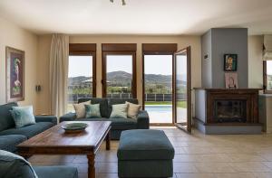 a living room with couches and a table and a fireplace at Olive Garden Villa Chania in Chania