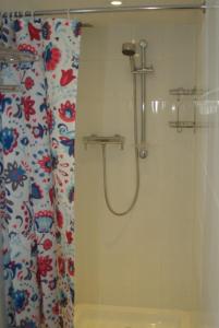 a shower in a bathroom with a shower curtain at The Coach House at Stowford House in Babcary