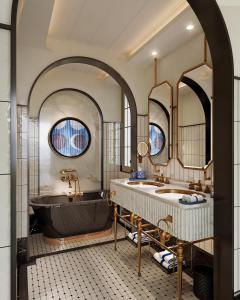 a bathroom with two sinks and a tub and two mirrors at La Festa Phu Quoc, Curio Collection By Hilton in Phu Quoc