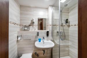 a bathroom with a sink and a shower at Aspire Castillo Reutlingen, Trademark Collection by Wyndham in Reutlingen