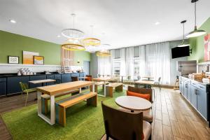 a cafeteria with tables and chairs and a kitchen at Spark by Hilton Fort Stockton in Fort Stockton