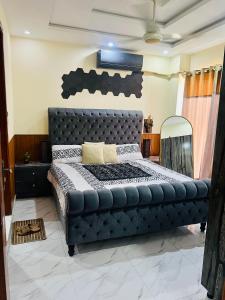 a bed in a room with a black leather bed frame at 1 one bed flat furnished Bahria Town Rawalpindi Islamabad in Rawalpindi