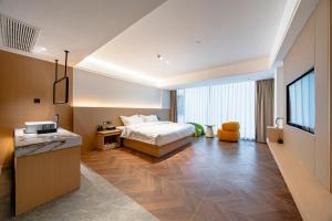 una habitación de hotel con una cama y un televisor en Ban Shan Du Hotel, en Yangshuo