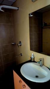 a bathroom with a sink and a mirror at Cherry Blossom Hideaway Elegant 3BHK Cozy Ambience With Pool in Dabolim