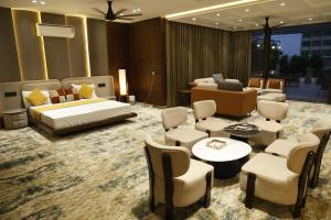 a hotel room with a bed and a couch and chairs at Siya Residency in New Delhi