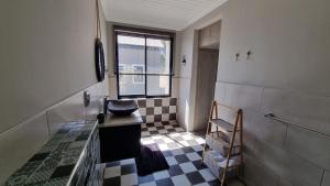 a bathroom with a sink and a checkered floor at Stay at 64 Omeya in Windhoek