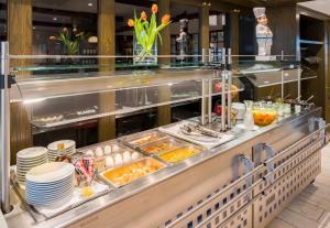 a buffet line with plates and food in a restaurant at Aspire Oldenburg, Trademark Collection by Wyndham in Oldenburg +82 photos