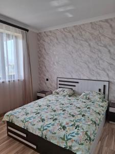 a bedroom with a bed with a floral comforter at Baleni Guesthouse Agritourism in Gyulagarak +33 photos