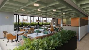 a restaurant with tables and chairs and plants at Hilton Garden Inn Mexico City Polanco in Mexico City