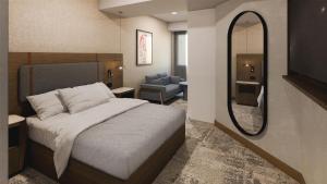a bedroom with a bed and a mirror and a chair at Hilton Garden Inn Mexico City Polanco in Mexico City
