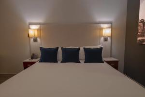 ロスモチスにあるEsplendor by Wyndham Los Mochis Country Placeの大きな白いベッドと青い枕のある寝室