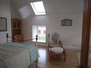 a bedroom with a bed and a chair and a window at Seod Na Mara, Jewel of the Sea, Upstairs Flat, Dun Geagan,Ballinskelligs in Ballinskelligs +23 photos
