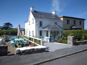 a white house with a picnic table and an umbrella at Seod Na Mara, Jewel of the Sea, Upstairs Flat, Dun Geagan,Ballinskelligs in Ballinskelligs