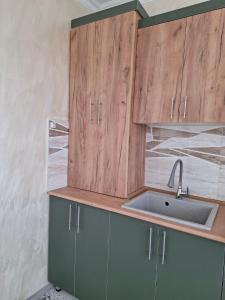 a kitchen with wooden cabinets and a sink at Baleni Guesthouse Agritourism in Gyulagarak