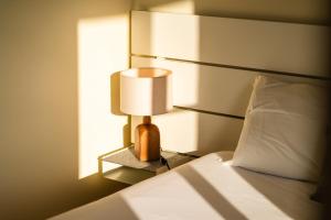 a bedroom with a bed and a lamp on a night stand at GuestReady - Sea-View Retreat in Madeira in Santo António