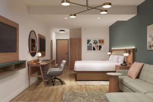 a hotel room with a bed and a couch at La Quinta Inn & Suites by Wyndham Tracy in Tracy
