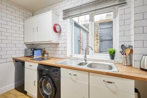 a kitchen with a sink and a washing machine at Host & Stay - The Reading Room in Hexham +11 photos