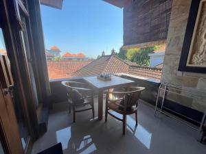 a table and chairs in a room with a large window at Twowi House Ubud in Ubud