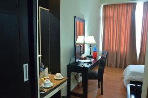 a room with a desk and a bed and a bedroom at Hotel Prasasti Pacitan in Pacitan
