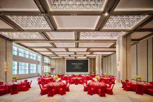 a conference room with red tables and chairs and a screen at Crowne Plaza Zhongshan Torch High-tech Zone by IHG in Zhongshan +36 photos