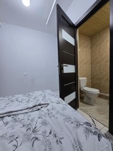 a bedroom with a bed and a bathroom with a toilet at Resta hostel in Yerevan