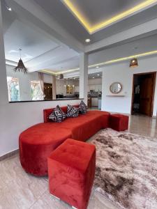 a large red bed in a living room with a rug at Villa malak in Aït Imouni