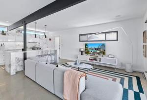 Il comprend un salon doté d'un mobilier blanc et d'une télévision. dans l'établissement Villa Marina Muse, à Palm Springs