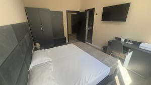 a bedroom with a bed and a desk and a television at Hotel Garden in Vidin +4 photos