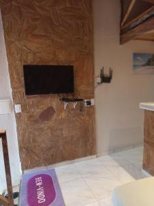 a room with a television on a wooden wall at Refúgio do Alto in Guaramiranga
