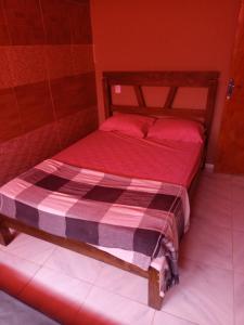 a bedroom with a bed with red sheets and red pillows at Refúgio do Alto in Guaramiranga +7 photos
