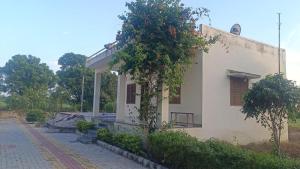 a small white building with a tree in front of it at Matra Chhaya farmhouse in Nāna