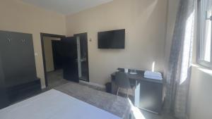 ein Hotelzimmer mit Schreibtisch und Fernseher an der Wand in der Unterkunft Hotel Garden in Widin