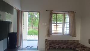 a room with a window and a couch in front of it at Matra Chhaya farmhouse in Nāna
