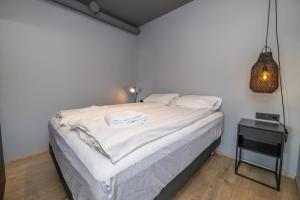 a bedroom with a bed with white sheets and a lamp at LL Properties - TB24 The Boutique Flat in Akureyri +5 photos