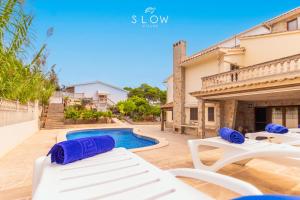 a villa with a swimming pool and lounge chairs at Villa Maravillas by Slow Villas in Playa de Palma