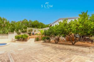a house with a courtyard with trees and a building at Villa Maravillas by Slow Villas in Playa de Palma