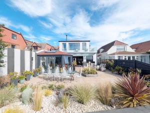 a house with a patio with chairs and plants at Elmer Road in Yapton