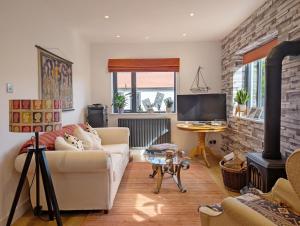 a living room with a couch and a fireplace at Elmer Road in Yapton