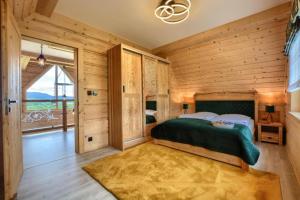 a bedroom with a bed and a large window at Widokówka Kluszkowce in Kluszkowce